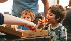 A family sharing a freshly made pizza